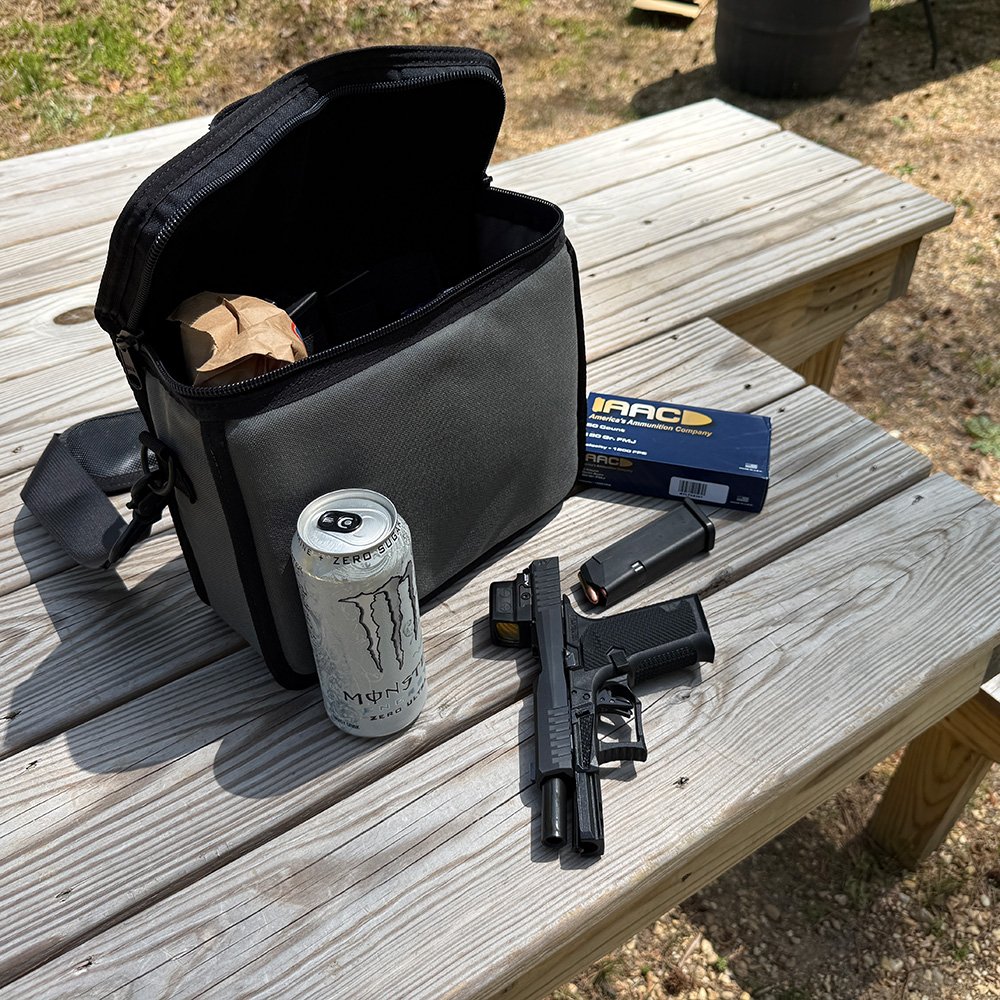 A handgun, magazines, and ammo laid out alongside the Lunch Box