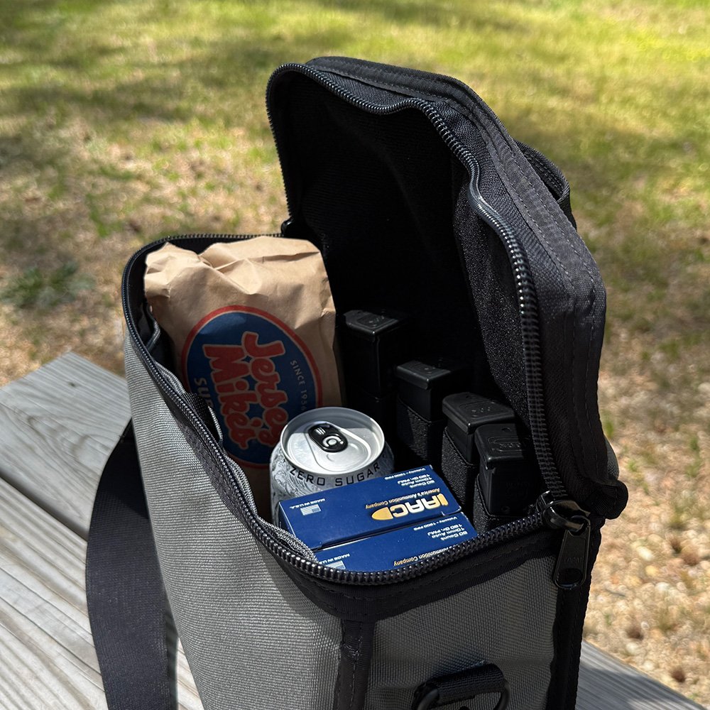 The Lunch Box bag pictured next to an actual lunch tray, illustrating its discreet form factor