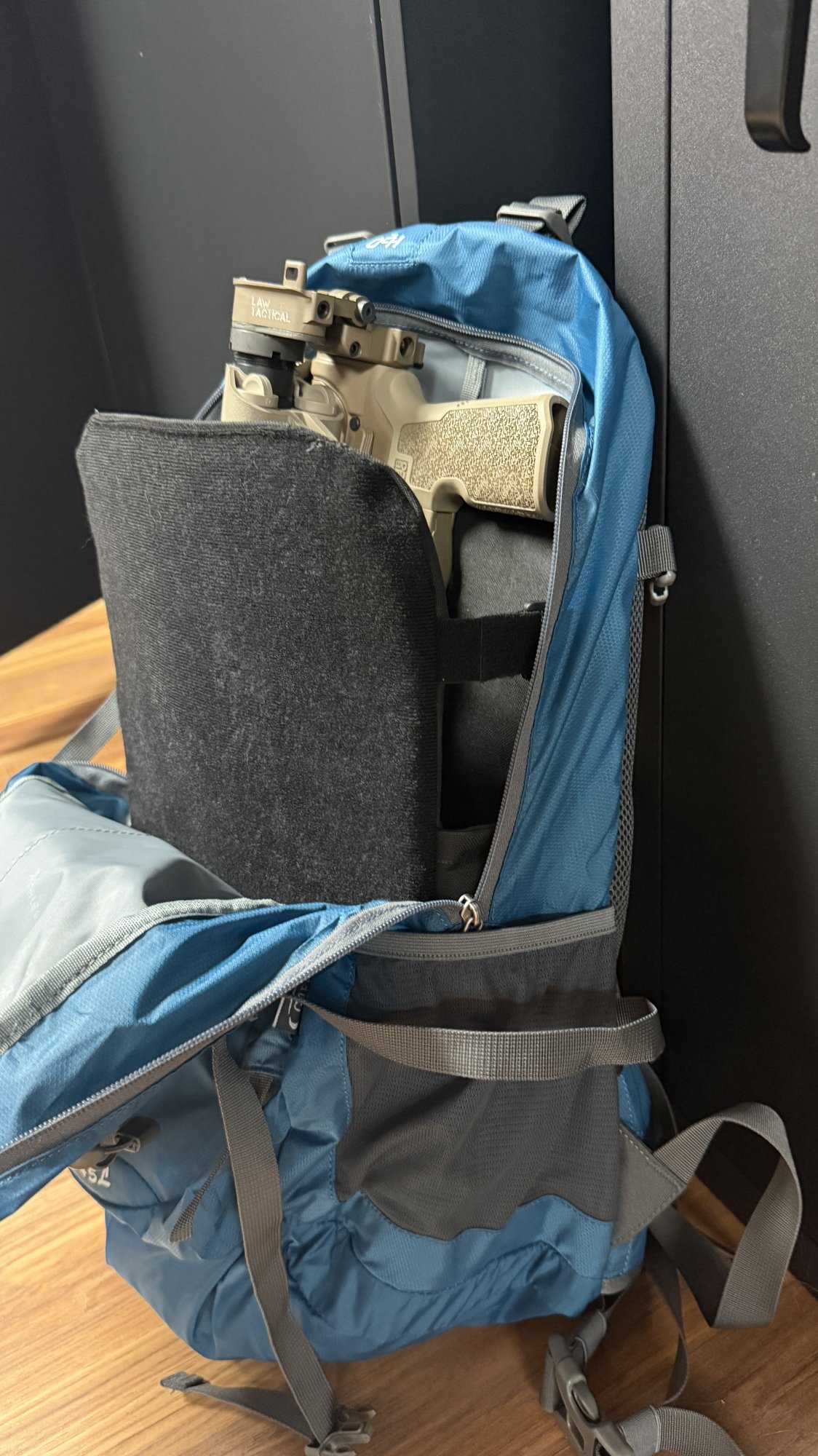 Policy XL insert installed in a blue hiking daypack with an AR pistol carried inside