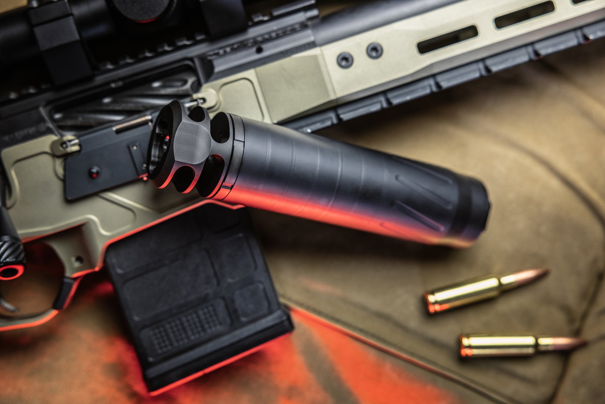 BANISH COMP 6.5 SS stainless suppressor with two-port brake on a chassis precision rifle